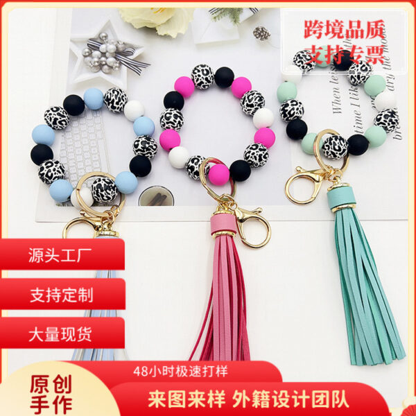 O1CN01dKTgoE1tKvZaLlMmc_2207986825884-0-cib Wholesale Leopard Print White Bottom Wooden Beads Rubber Paint Round Beads PU Tassel Bracelet Keychain
