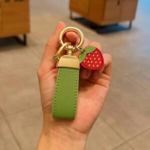 Green keychain + strawberry with golden horseshoe buckle