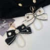 Wholesale Black and white color Chanel style camellia pearl chain bow keychain