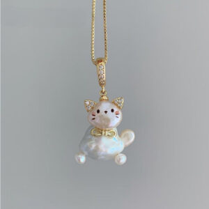 The kitten sits on a gold necklace