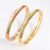 Wholesale Geometric Bangle For Women In Golden Titanium Steel With Electroplated Finish And Rhinestone Inlay