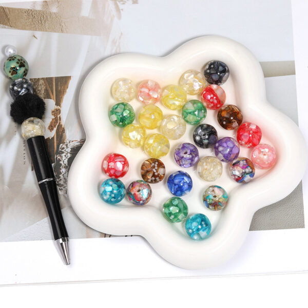 oly-1fca35731c365c744c9063dbeb76d415 Wholesale Irregularly shaped, vibrant mother-of-pearl inlaid with translucent, perforated beads.