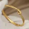 Wholesale 304 Stainless Steel Twist Ion Plating (IP) Real Gold Plated Simple Style Classic Style Waterproof Non Tarnish Asymmetrical Buckle Gold Bangle