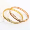 Wholesale Geometric Bangle For Women In Golden Titanium Steel With Electroplated Finish And Rhinestone Inlay