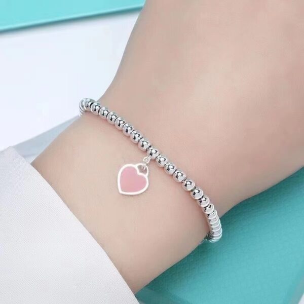 Wholesale brass-plated sier heart bracelet with enamel blue, red, and pink hearts. High-value women's bracelet, opshipping available.
