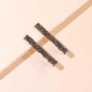A pair of black diamond and gold bottom hairpins