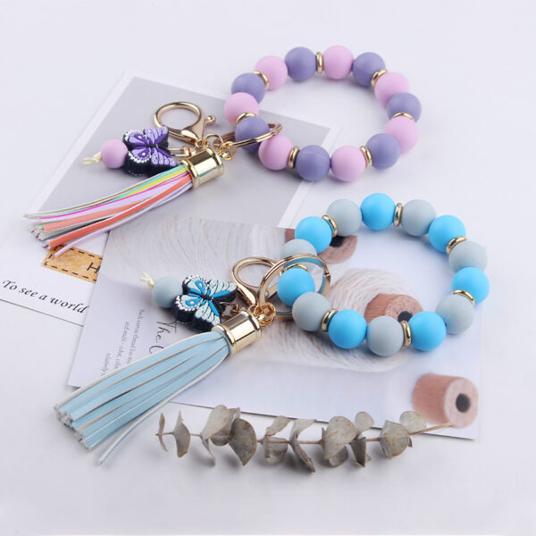 oly-32b325dc03da9c064dbe112d0e337a3e Wholesale Creative DIY Beaded Cartoon Butterfly Wrist Keychain Pendant Rainbow Leather PU Tassel Ring Key Ring Accessories