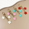 oly-390c7af2b8ae5623ba70b724b424a623 Wholesale double-sided drip oil color flower alloy keychain creative Airpods bag pendant