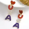 oly-58f228a5c4fac6028fbaffeb4976df4f Wholesale 1 Pair IG Style Retro Classic Style Letter Inlay Alloy Seed Bead Drop Earrings