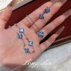 Wholesale Copper zircon four-leaf clover necklace, bracelet, and earrings set with red corundum, aquamarine, and white diamonds.