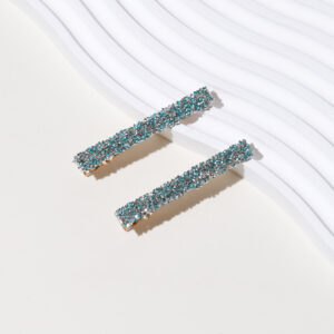 A pair of hairpins with green diamond and gold bottom