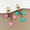 oly-ec0f5a53c6dd95ba8e50f974443f5b8b Wholesale double-sided drip oil color flower alloy keychain creative Airpods bag pendant