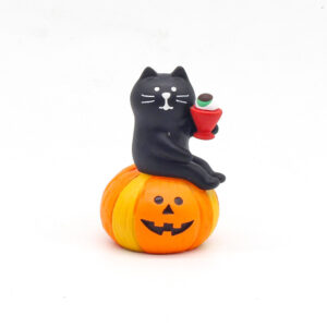black cat sitting on pumpkin